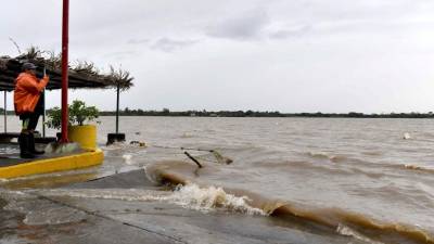 Un hombre graba un video de la crecida del río Tecolutla.