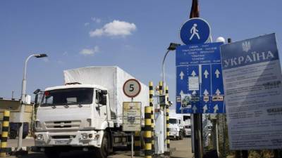 Un hombre maneja un camión que hace parte del convoy humanitario ruso mientras cruza la frontera de Ucrania.