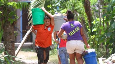 Pobladores en la comunidad de Las Delicias se ven obligados a caminar hasta el río Danto para llevar en contenedores el agua a sus casas. Foto: Esaú Ocampo