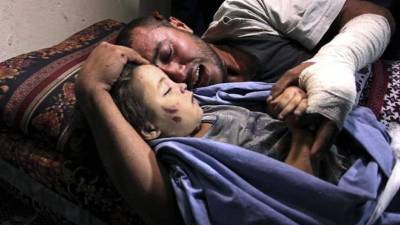 Fotografía facilitada por el fotoperiodista palestino Ashraf Abu Amra que capta la imagen de dolor de un padre en Gaza que ha perdido a su hija de dos años durante un ataque israelí el 11 de octubre de 2015 en el campo de refugiados de Nuseirat, que ha sido galardonada con el segundo premio del concurso 'Andrei Stenin International Press Photo' en la categoría de Noticias Más Importante. EFE