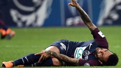Dani Alves en el suelo doliéndose de la lesión en su pierna derecha. Foto AFP