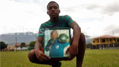 Josué Núñez, hijo de 'Tyson', posando con una foto de su padre.
