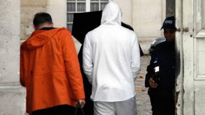 Benzema (de blanco) al momento de llegar a las instalaciones de la Policía Judicial en Versalles. Foto AFP
