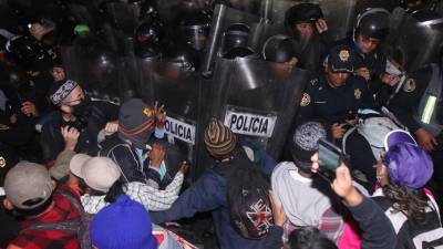 Migrantes de la caravana se enfrentan a la policía a su llegada a la Basílica.