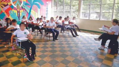 Estudiantes recibiendo sus clases en una aula de un centro educativo público en el departamento de Yoro.