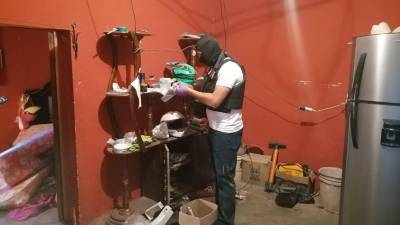 Agentes policiales inspeccionando la vivienda de Carlos Alberto García en el municipio de San Agustín, Copán.