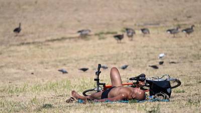 Un hombre toma el sol en un parque de Londres, donde la ola de calor extremo llegará esta lunes tras castigar a España, Portugal y Francia.