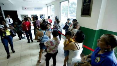 Pacientes llegan a la ventanilla BAC del IHSS a cobrar.