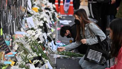 Jóvenes surcoreanos rinden tributo a las 154 víctimas de la estampida en una fiesta de Halloween en Itaewon.