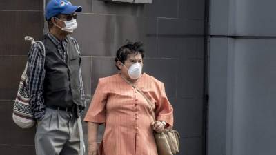 Una pareja se protege con mascarillas en las calles de San José, Costa Rica. Fotos: AFP