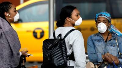 Mujeres usan mascarillas protectoras fuera de la terminal internacional en el aeropuerto Kennedy en Queens, Nueva York. EFE