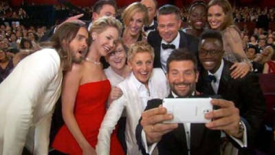 El actor Bradley Cooper saca una foto con un teléfono inteligente de Samsung durante la ceremonia de los Oscar.