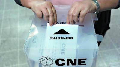 Ciudadana deposita su voto en una urna del Consejo Nacional Electoral.