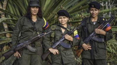 (L to R) Luisa, Manuela and Rosmira, members of the Revolutionary Armed Forces of Colombia (FARC), pose for a picture at a camp in the Colombian mountains on February 18, 2016. Many of these women are willing to be reunited with the children they gave birth and then left under protection of relatives or farmers, whenever the peace agreement will put an end to the country's internal conflict. AFP PHOTO / LUIS ACOSTA