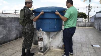 Un soldado y un trabajador del ministerio de salud brasileño revisan un depósito de agua en Sao Paulo. Brasil reporta la mayor incidencia de casos de zika.
