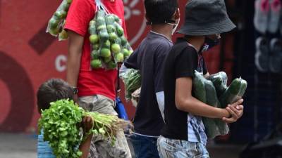 Los niños venden frutas y verduras en la calle en Tegucigalpa en medio de la pandemia del coronavirus. AFP