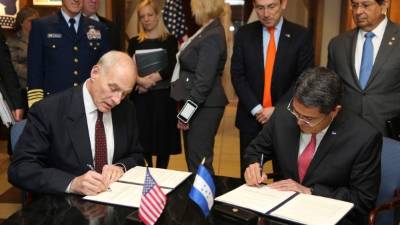 Juan Orlando Hernández y John Kelly son acompañados por altos funcionarios durante la firma del convenio.