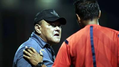 Carlos Caballero dialoga con el cuarto árbitro del partido Real España-Marathón.