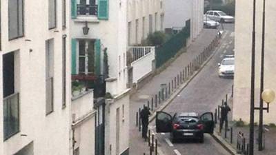 Hombres armados se enfrentan a agentes de la policía cerca de las oficinas del periódico satírico francés Charlie Hebdo en París el 7 de enero de 2015, durante un ataque contra las oficinas del diario que dejó doce muertos, entre ellos dos policías, según fuentes cercanas a la investigación. AFP