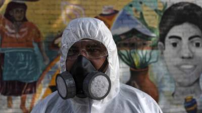 A municipal worker participates in a disinfection operation at eastern neighborhoods as a measure to prevent the spread of the new coronavirus, COVID-19, in San Salvador on March 18, 2020. - The president of El Salvador, Nayib Bukele, announced on Tuesday the closure of the country's main airport to passenger flights. Only the transit of cargo planes and humanitarian missions will be allowed, due to the coronavirus pandemic. (Photo by Yuri CORTEZ / AFP)