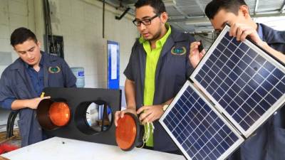 Arnold Gutiérrez, David Pinett y Kevin Lara mientras ensamblan uno de los semáforos solares que instalarán en diferentes zonas de tránsito en la ciudad. Foto: Jordan Perdomo