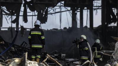 Bomberos apagan el incendio en un edificio bombardeado por las tropas rusas.