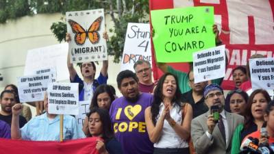 'Trump, eres un cobarde', se lee en uno de los cárteles de los manifestantes por DACA en la Casa Blanca. AFP.