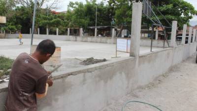 Un trabajador pica en una de las partes de la estructura de la cancha que tendrá nueva imagen.