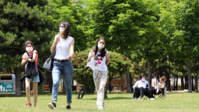 People wearing face masks to protect against the spread of coronavirus, visit a park in Ankara on June 18, 2020. - Turkish authorities have made the wearing of masks mandatory in three major cities to curb the spread of COVID-19 following an uptick in confirmed cases since the reopening of many businesses. (Photo by Adem ALTAN / AFP)