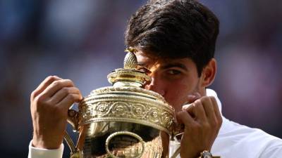 Momento donde Alcaraz besa el trofeo conquistado tras vencer a Djokovic en la final de Wimbledon.