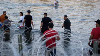 Un grupo de migrantes centroamericanos cruzan el río Grande en la frontera de Estados Unidos.