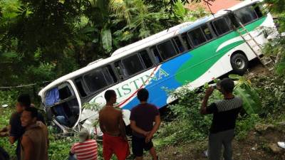 El bus de Cristina que viaja de La Ceiba a Tegucigalpa quedó en una hondonada. Fotos: Claros y Efraín Molina.