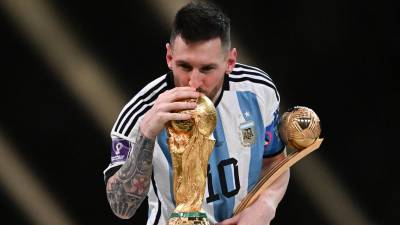 Lionel Messi besando el trofeo de la Copa del Mundo.