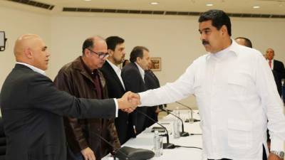 El presidente Nicolas Maduro saluda Jesús Torrealba, un representante de la oposición venezolana.