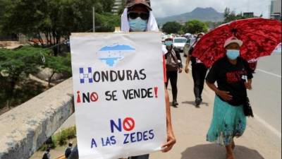 Imagen de archivo de un hombre sosteniendo un cartel durante una protesta contra las zede en Tegucigalpa.