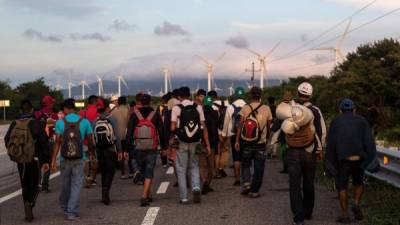 A group of Honduran migrants taking part in a caravan heading to the US walk along the road on their way to Juchitan, near the town of La Blanca in Oaxaca State, Mexico, on October 30, 2018. - The Pentagon is deploying 5,200 active-duty troops to beef up security along the US-Mexico border, officials announced Monday, in a bid to prevent a caravan of Central American migrants from illegally crossing the frontier. (Photo by GUILLERMO ARIAS / AFP)