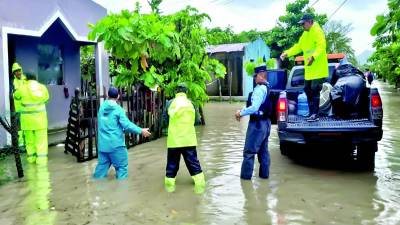 <b>Rescatistas llegaron a una de las viviendas en Choloma para evacuar a propietarios mientras el agua avanzaba.</b>