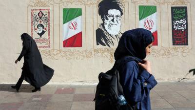 Mujeres iraníes caminan junto a un mural del difunto líder supremo iraní, el ayatolá Ali Jamenei, en una calle de Teherán, Irán, este miércoles. EFE/EPA