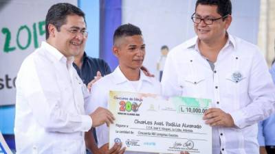 El presidente Hernández y el ministro de Educación entregan premio a un estudiante. Foto Y. Amaya