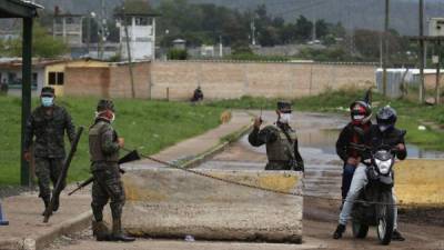 Militares hondureños vigilan en un reten afuera del Centro Penitenciario Nacional de Tamara el 28 de mayo de 2020 al norte de Tegucigalpa (Honduras). EFE/Gustavo Amador