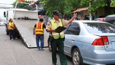 Las grúas levantan el mayor número de vehículos mal estacionados en la tercera avenida.