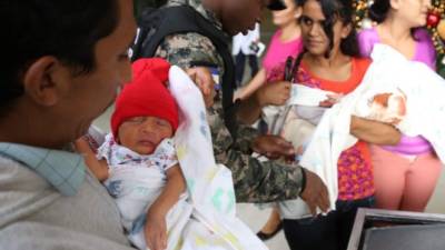 Los trillizos cargados por sus padres y una familiar en la salida del Rivas.