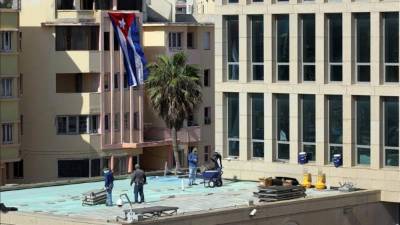 Tres jóvenes marines izaron hoy la bandera de Estados Unidos en la embajada de este país es el Malecón de La Habana, que recibieron de los tres militares que la habían arriado en 1961.