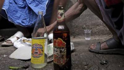 Imagen de dos botellas de alcohol local recién compradas en una licorería de Calcuta, India. EFE/Archivo
