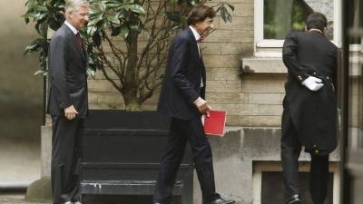 El primer ministro belga, Elio Di Rupo (centro), a su llegada a una reunión con el rey Felipe de Bélgica para presentar su dimisión.