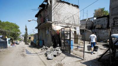 A man carries bucket filled with water at low-income neighborhood in Mexico City, April 9, 2009. The Mexican capital, one of the most densely populated cities in the world, cut in water supply to a historic fall in reserves, a measure that affects at least five million people, according to authorities. (AP Photo/Eduardo Verdugo)