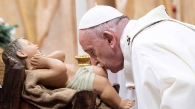 El Papa Francisco besa al niño Jesús mientras dirige la Santa Misa de Navidad en la Basílica de San Pedro en el Vaticano. EFE