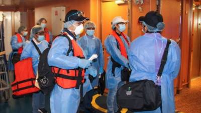 Miembros del Ministerio de Salud esperan a turistas a su llegada al Puerto de Amador en la Ciudad de Panamá.(Photo by Panama's Health Ministry presss Office / AFP)