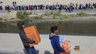 Migrantes venezolanos cruzan el Río Bravo para vender pizzas y bebidas a indocumentados que intentan ingresar a Estados Unidos.