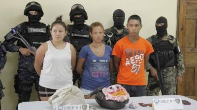 Los sospechosos junto a las evidencias decomisadas.